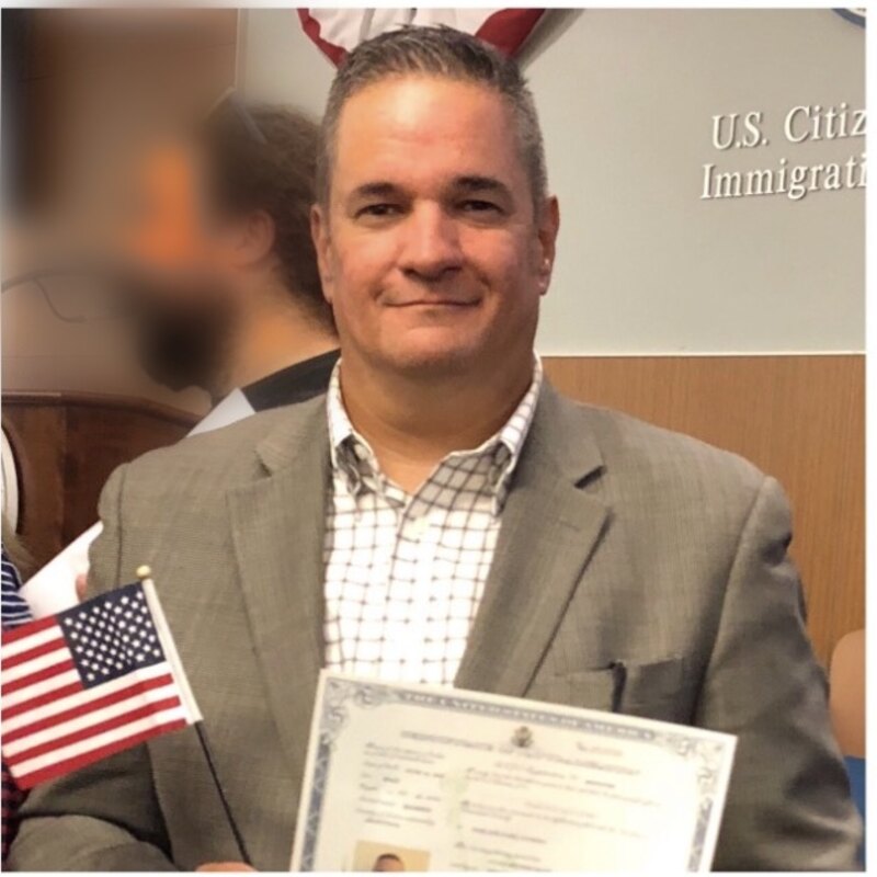 El creador de Mis Papeles USA el día de su ceremonia de ciudadanía en 2018, con su certificado y la bandera de EE. UU.